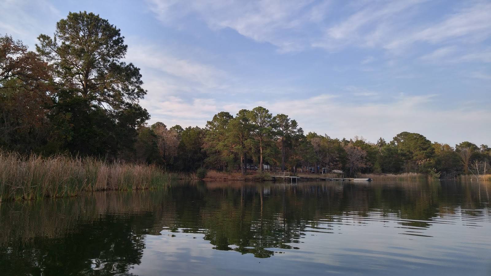 Kayak Fishing Lake Bastrop Shoreline with trees and beautiful calm water.